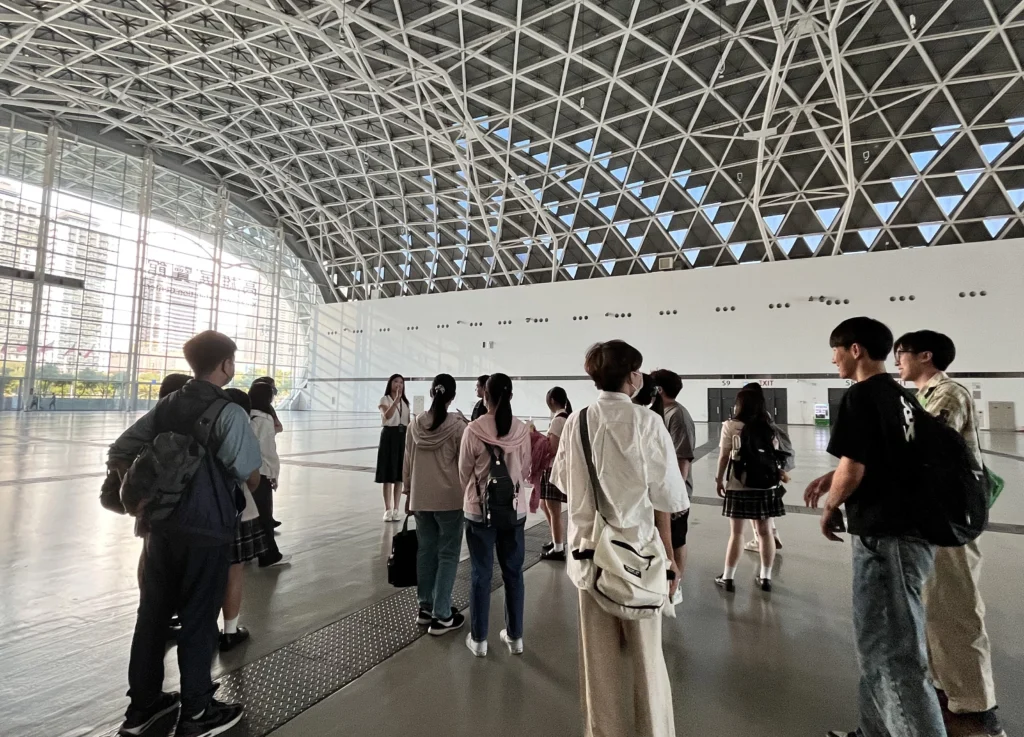 圖說：參與職場體驗的學員在「亞灣新創大南方」舉辦前夕參訪高雄展覽館，並在館方人員的解說下，了解參展廠商進駐配置及流程規劃細節。